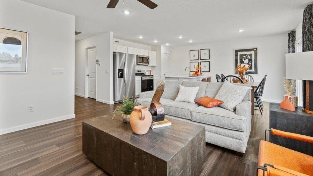 aldridge living room with lvp flooring, white walls, ceiling fan, and 2 windows