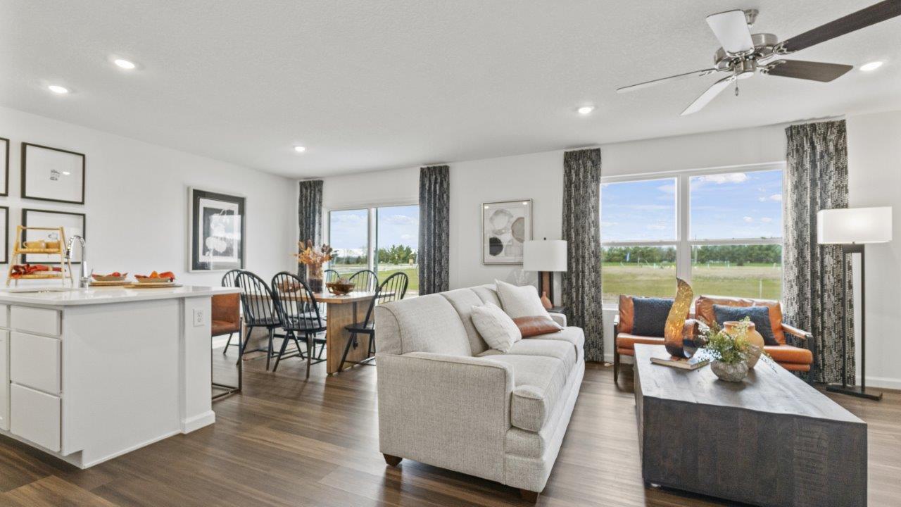 aldridge living room with lvp flooring, white walls, ceiling fan, and 2 windows