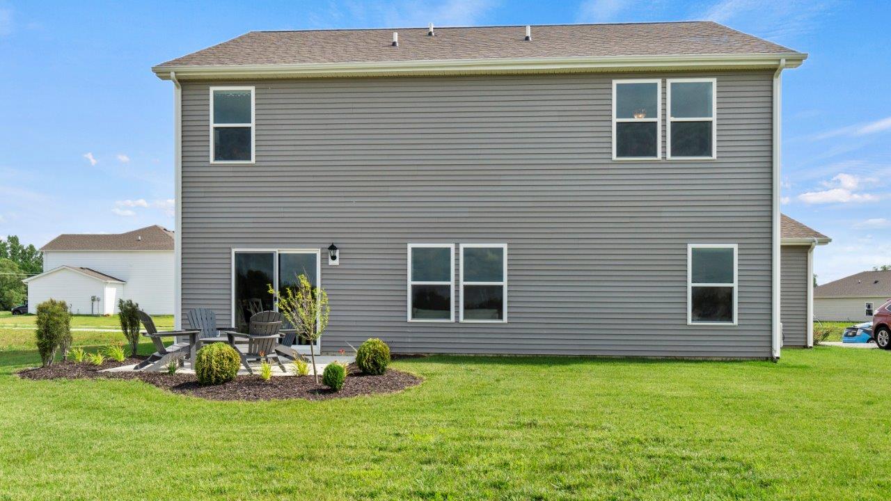 rear exterior with concrete patio and large sodded yard