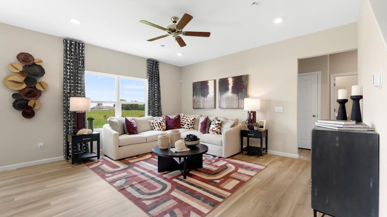 henley living room lvp, fan, and windows letting in antural lighting