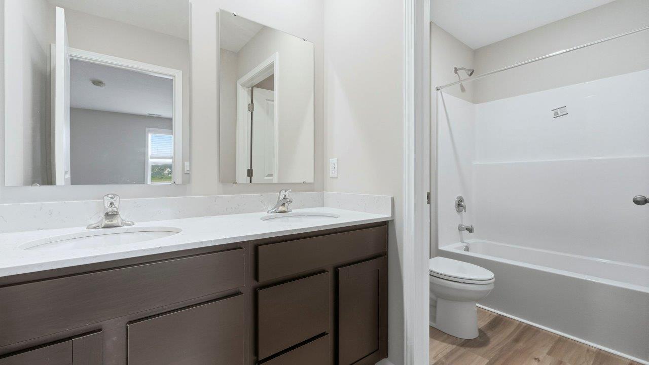 full bathroom with privte water room, tub shower, and dual sinks