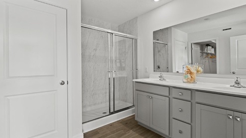 Estates at Signal Ridge Chatham model home bathroom off of main bedroom with dual vanity sinks and shower with cultured white marble.