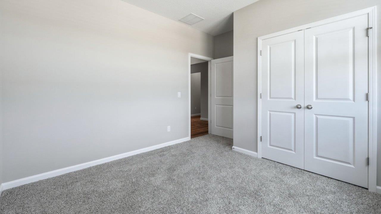 estates at signal ridge harmony villa bedroom with carpet flooring and ensuite closet