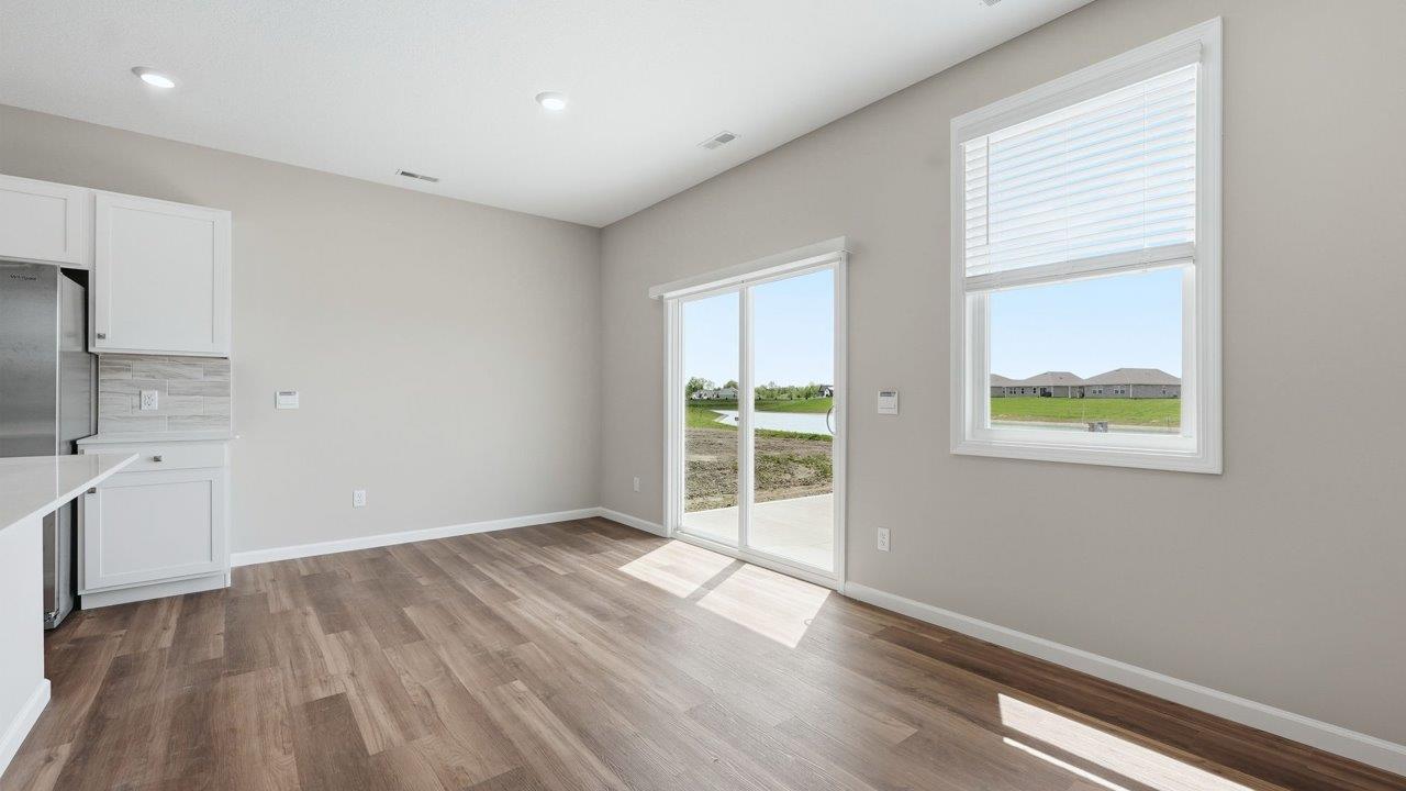 estates at signal ridge harmony villa dining space with lvp flooring and sliding glass door to backyard