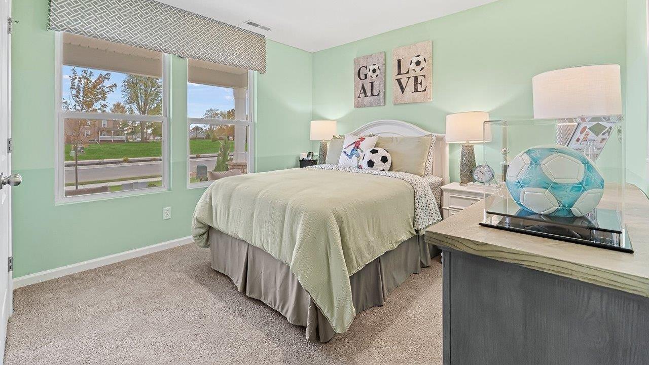 bedroom 2 with 2 windows, carpet, green walls, and closet