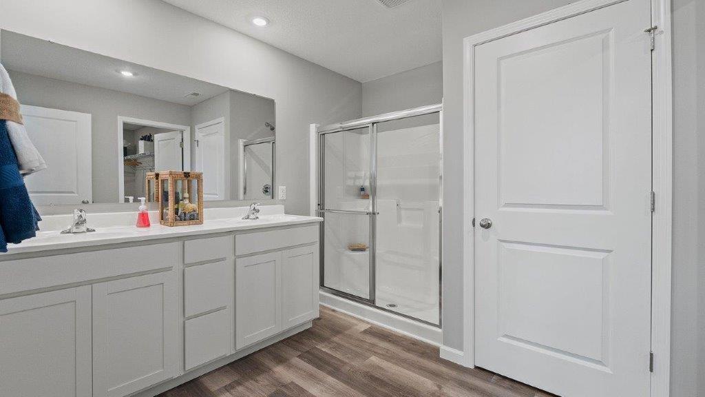 primary ensuite bathroom with dual sinks, private water room, and walk-in shower