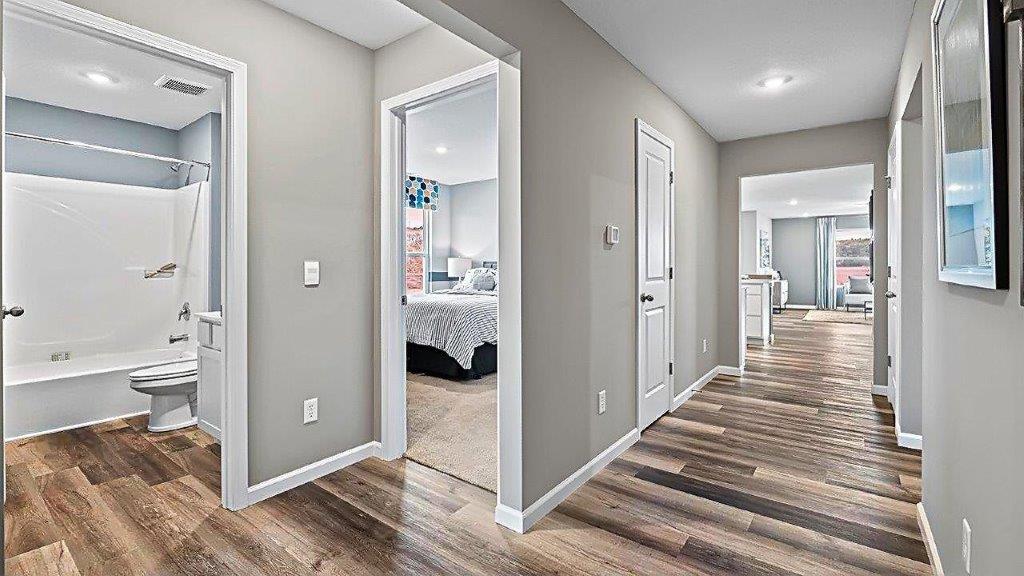 foyer with lvp flooring and grey walls leading to main living area