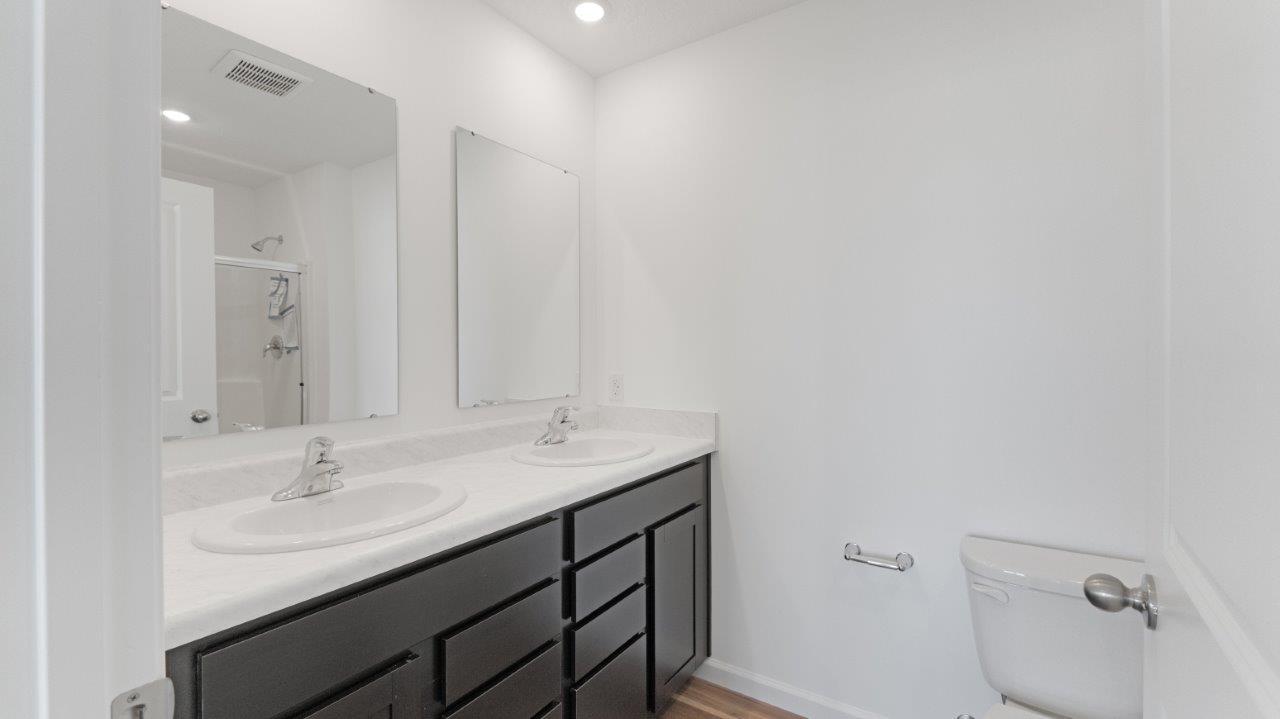 primary ensuite bathroom with dual sinks and walk-in shower