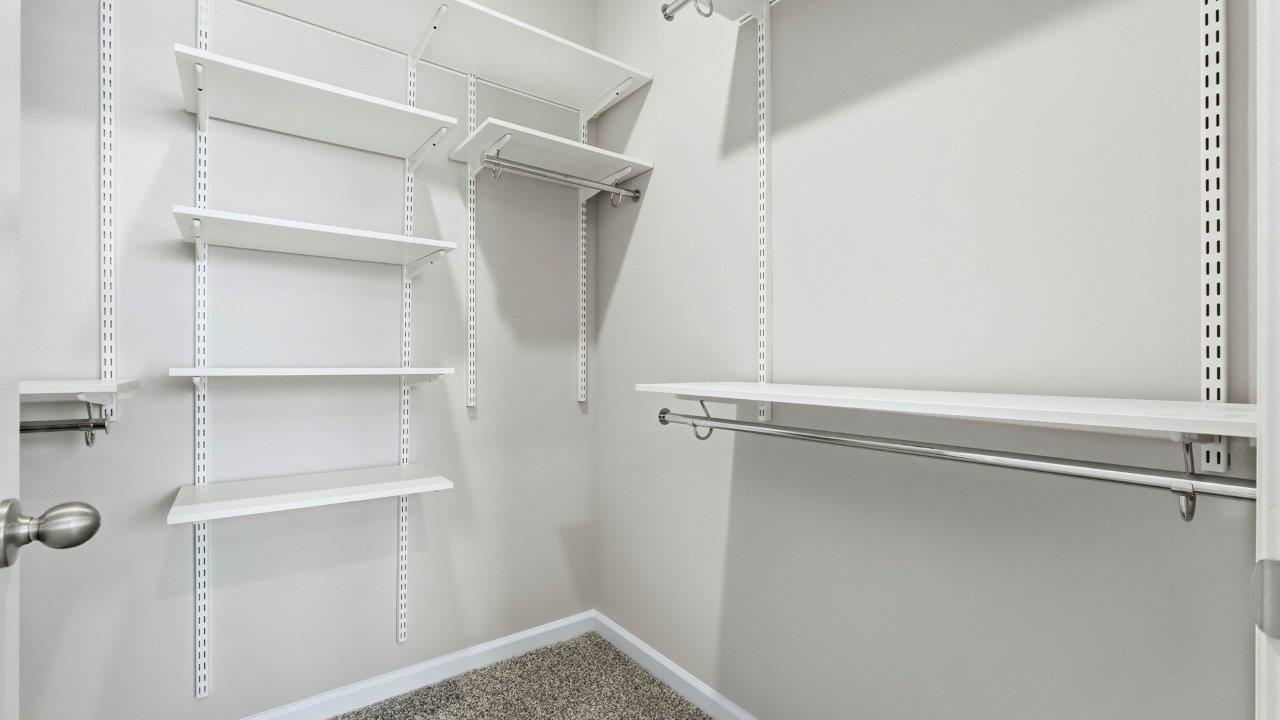 primary ensuite walk in closet with freedom rail shelving