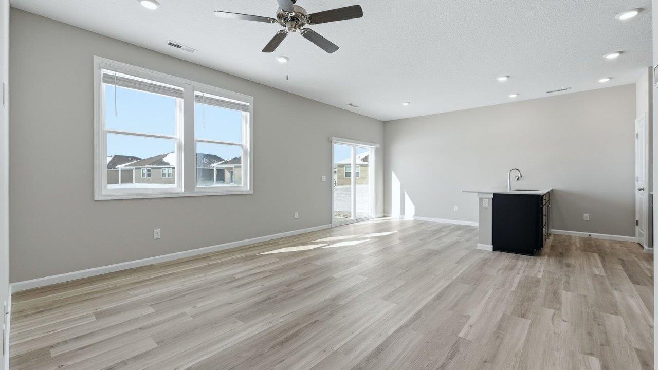 kitchen with sarsaparilla shaker cabinets, quartz counters, stainless steel appliances, ceramic tile backsplash, and island with seating
