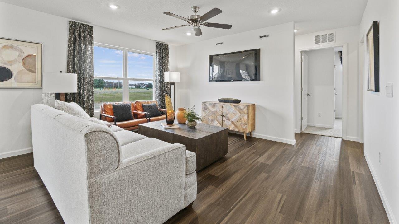 aldridge open plan living room with lvp flooring, fan, windows, and white walls
