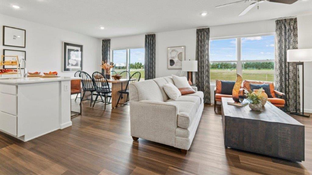 aldridge open plan living room with lvp flooring, fan, windows, and white walls