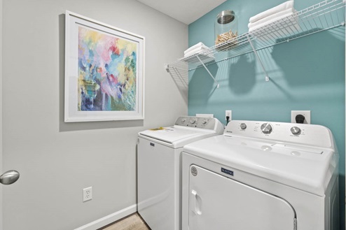 Timber Creek Chatham Model Home - Laundry room with washer, dryer, wire shelving, and LVP flooring.