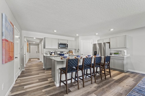Timber Creek Chatham Model Home - kitchen island with room for seating and LVP flooring.