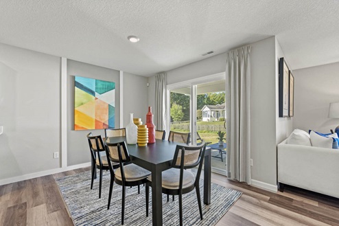 Timber Creek Chatham Model Home - dining room space in open floor plan first floor by the sliding glass door leading to the backyard.