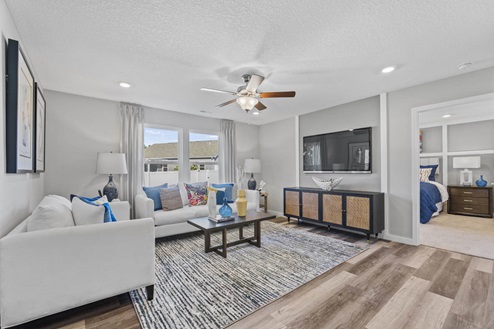 Timber Creek Chatham Model Home - Living room with LVP flooring and 52" ceiling fan.