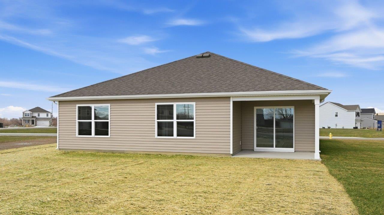 rear exterior with covered patio and large backyard