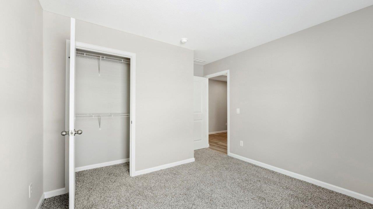 bedroom 3 with beige carpet, popular grey walls, and ensuite closet