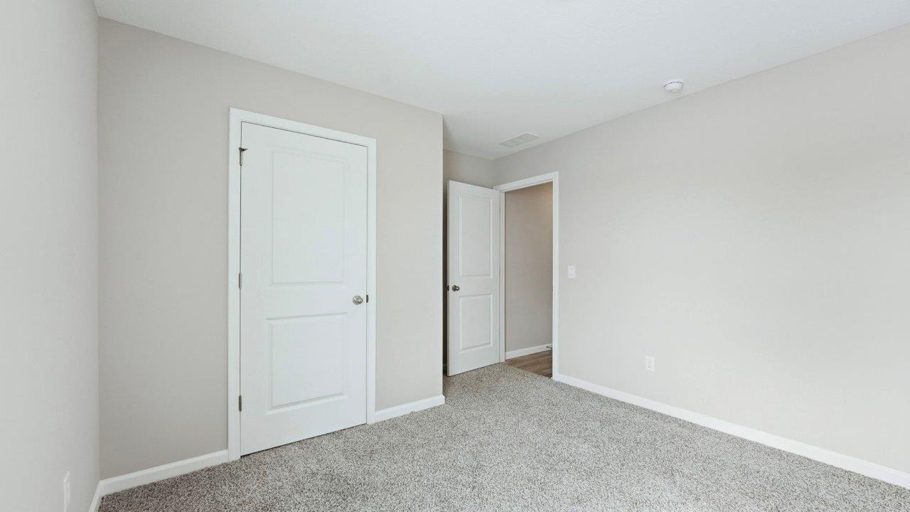 bedroom 4 with beige carpet, popular grey walls, and ensuite closet
