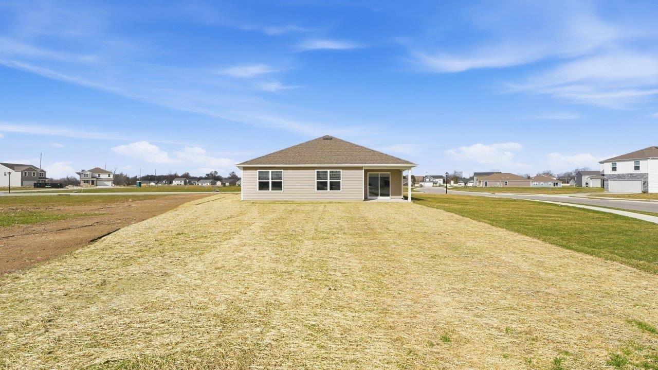 rear exterior with covered patio and large backyard