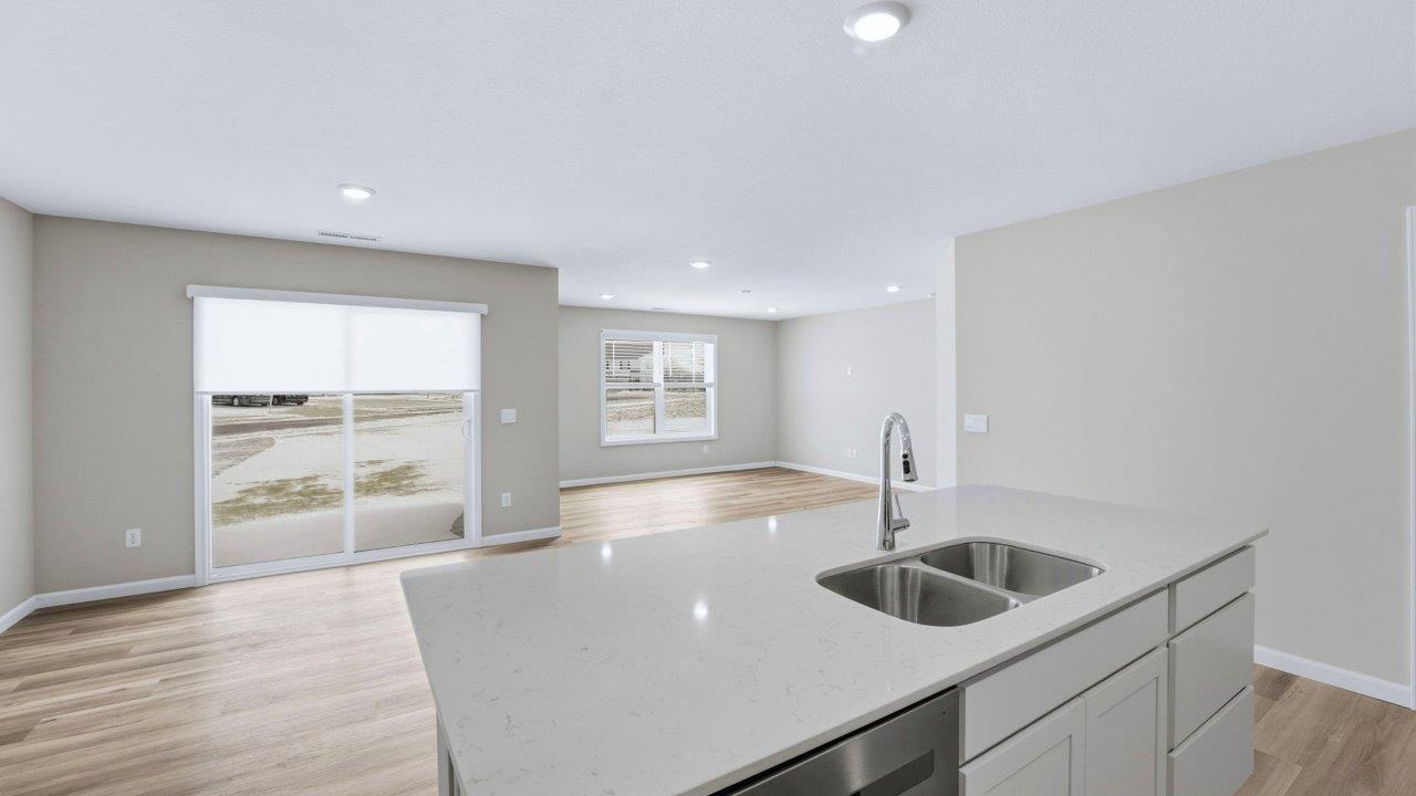 kitchen with white shaker cabinets, lvp flooring, stainless steel appliances, quartz counters, center island with bar seating, and corner pantry