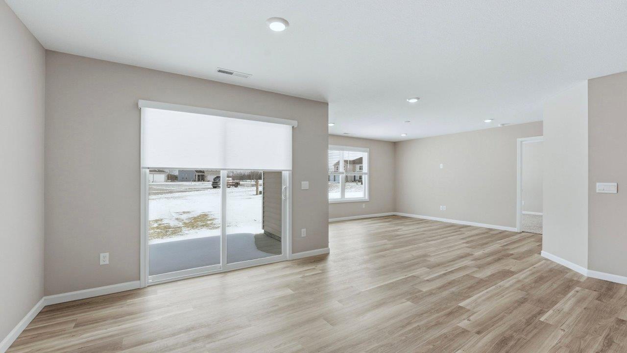 casual dining room with lvp flooring and sliding glass door to backyard patio