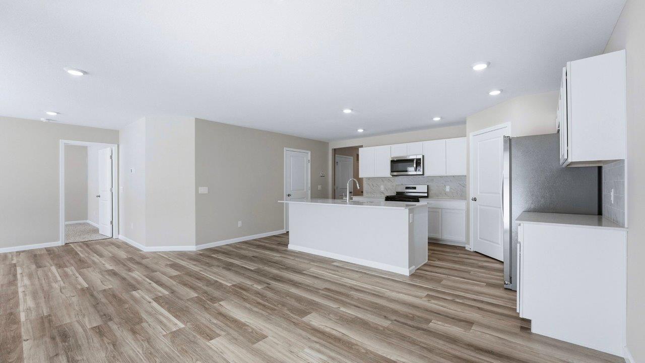 kitchen with white shaker cabinets, lvp flooring, stainless steel appliances, quartz counters, center island with bar seating, and corner pantry
