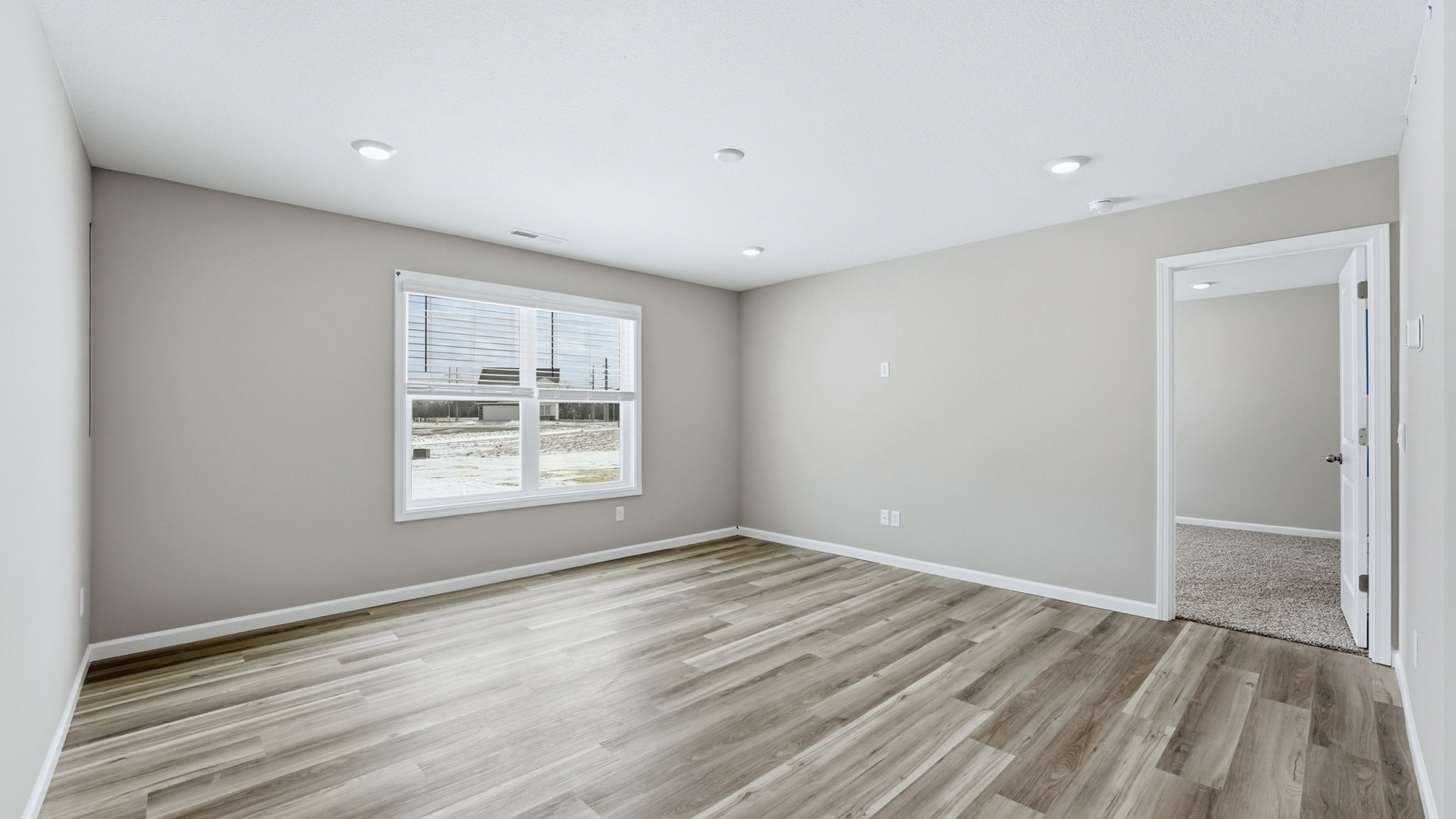 open layout living room with lvp flooring and large windows