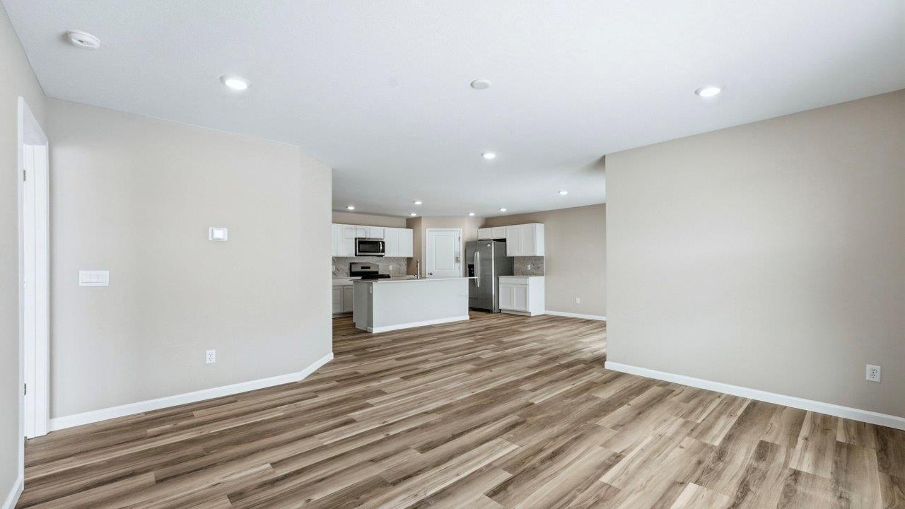 living room with lvp flooring, popular grey walls, 2 windows