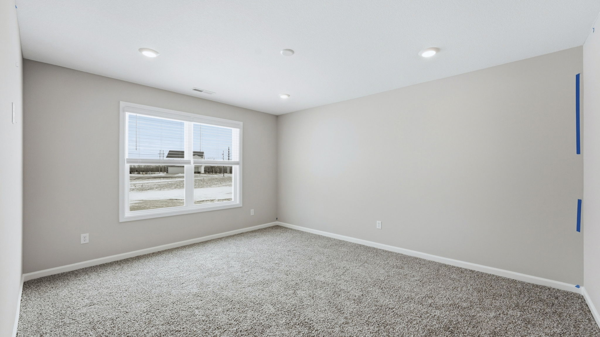 primary bedroom with carpet, two windows, and ensuite bath and closet