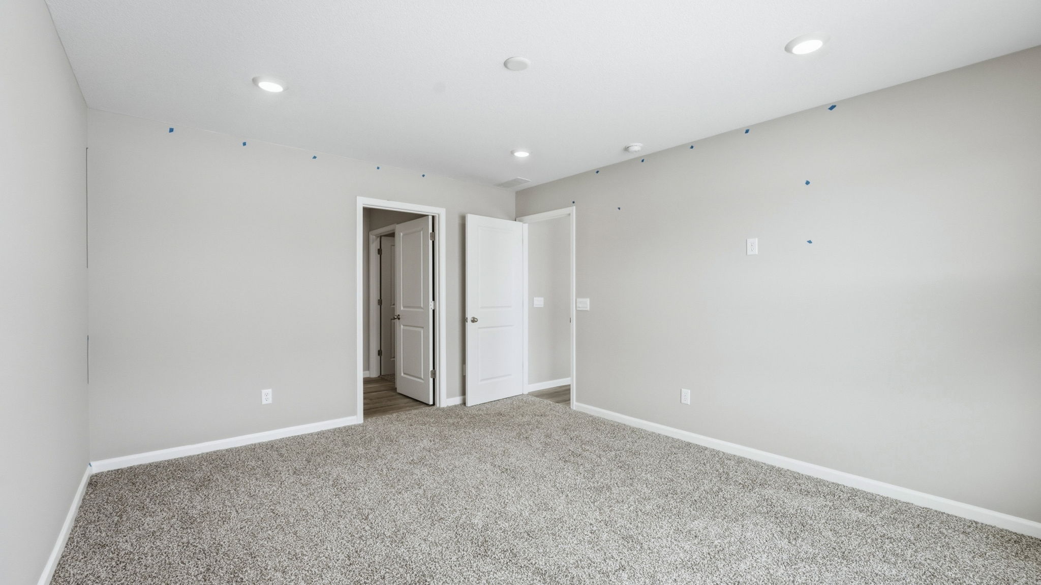primary bedroom with carpet, two windows, and ensuite bath and closet