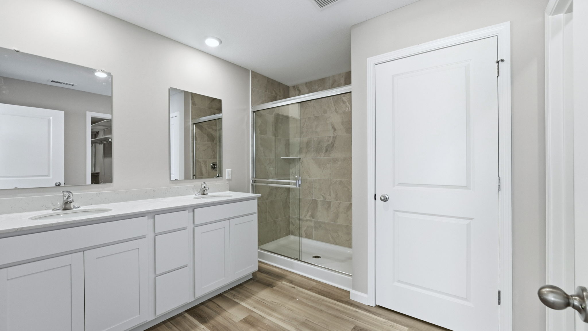 primary ensuite bath with dual sinks, tile walk in shower, and private water room