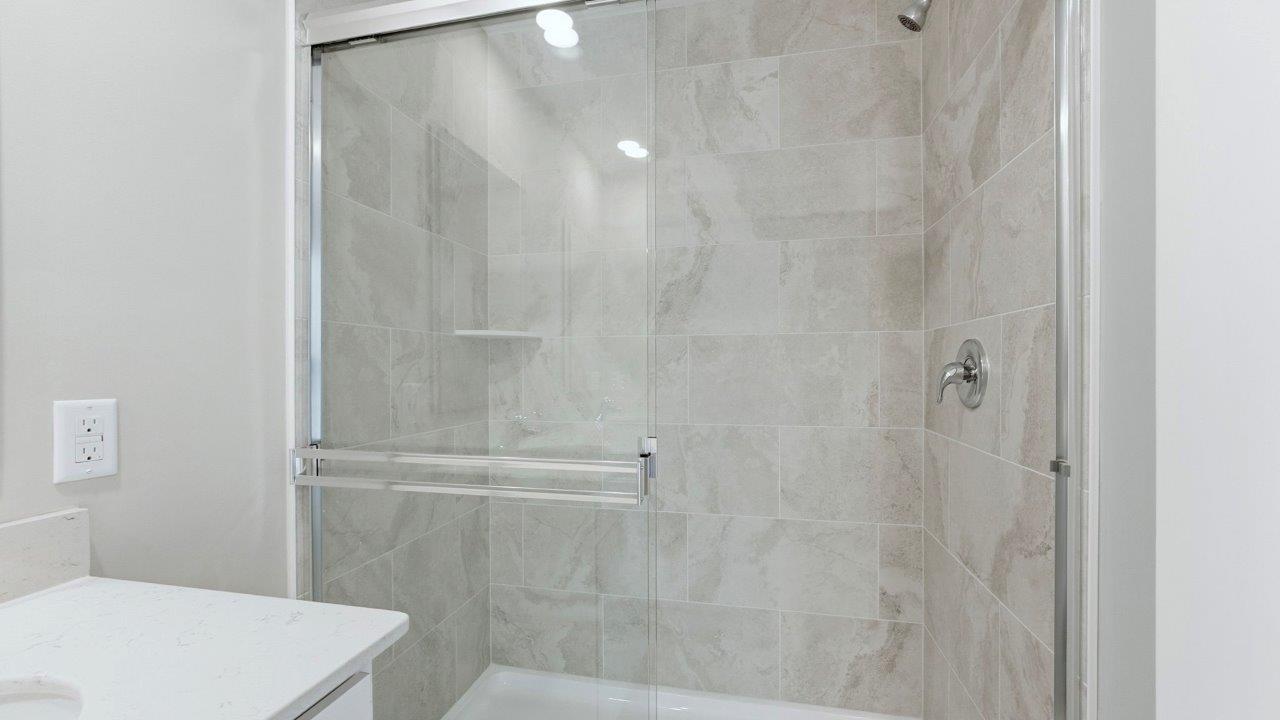 primary ensuite bathroom with dual sinks, white cabinets, lvp flooring, ceramic tile walk-in shower, and private water room