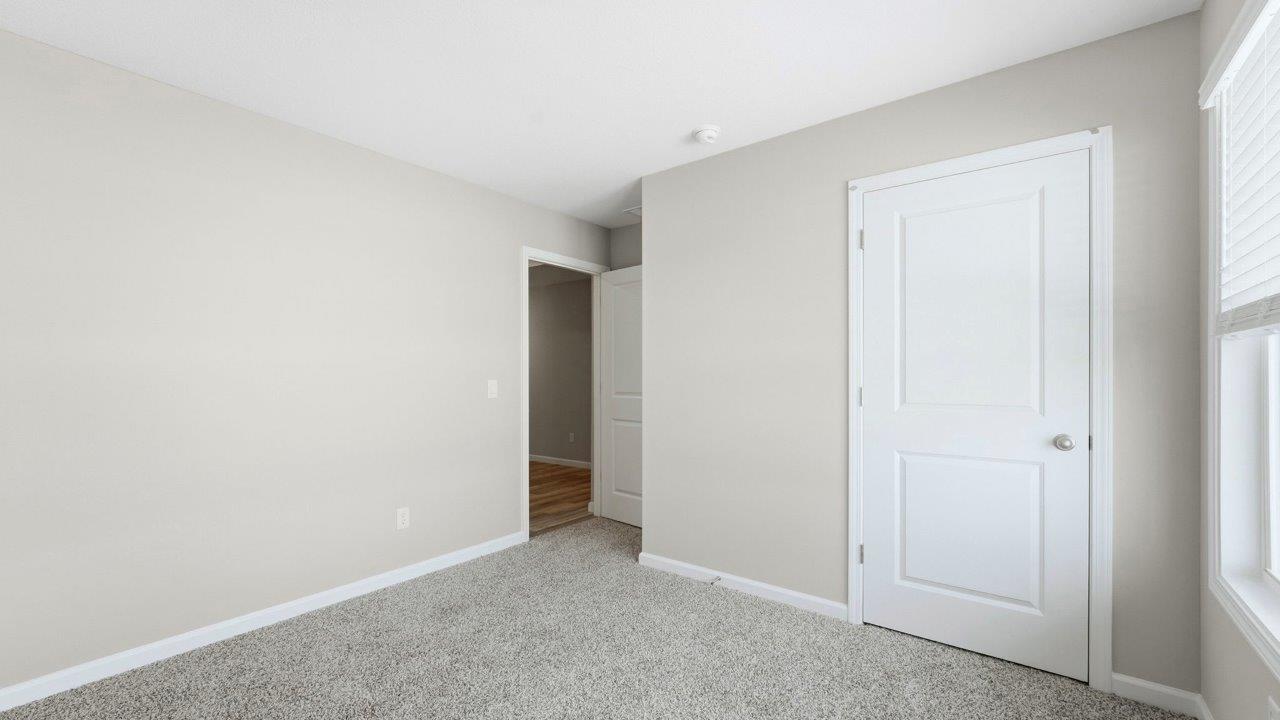 bedroom 2 with beige carpet, popular grey walls, and ensuite closet