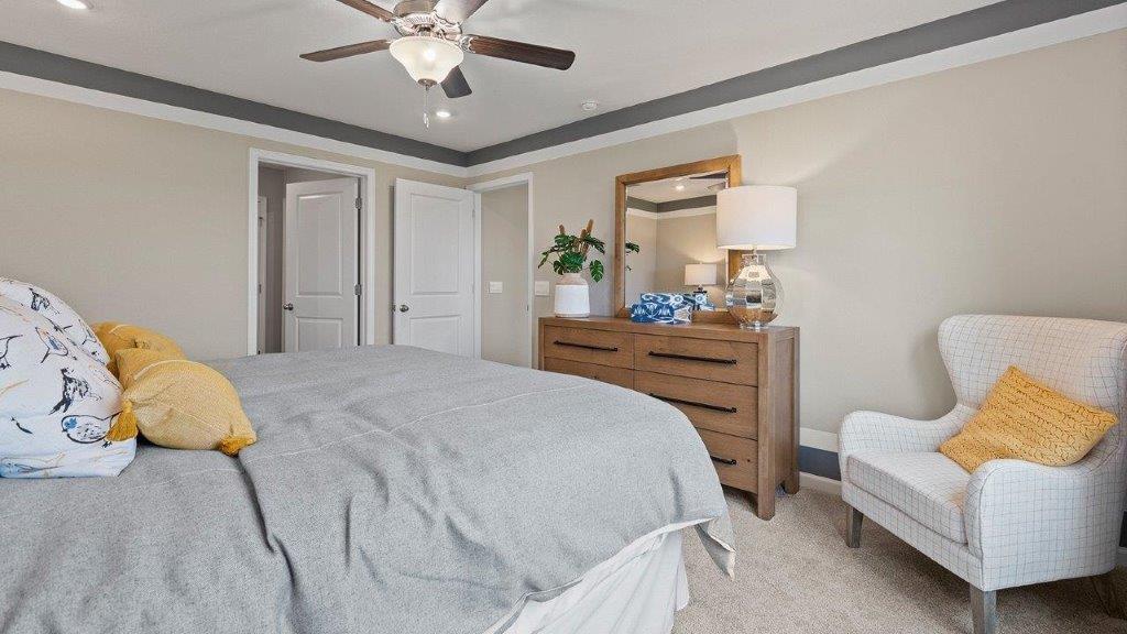 Chatham primary bed with ensuite closet and bath. Carpet, fan, and natural lighting.