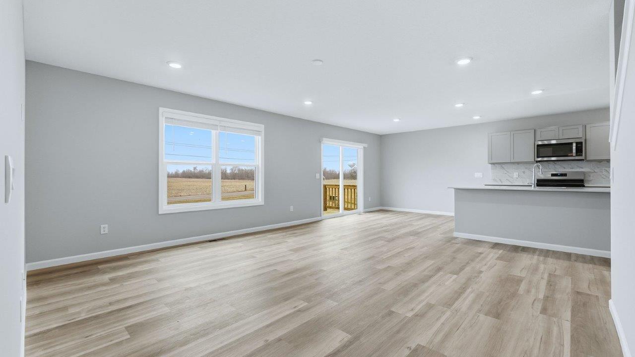 open layout living room with mohawk avery lvp, popular grey walls, and large windows