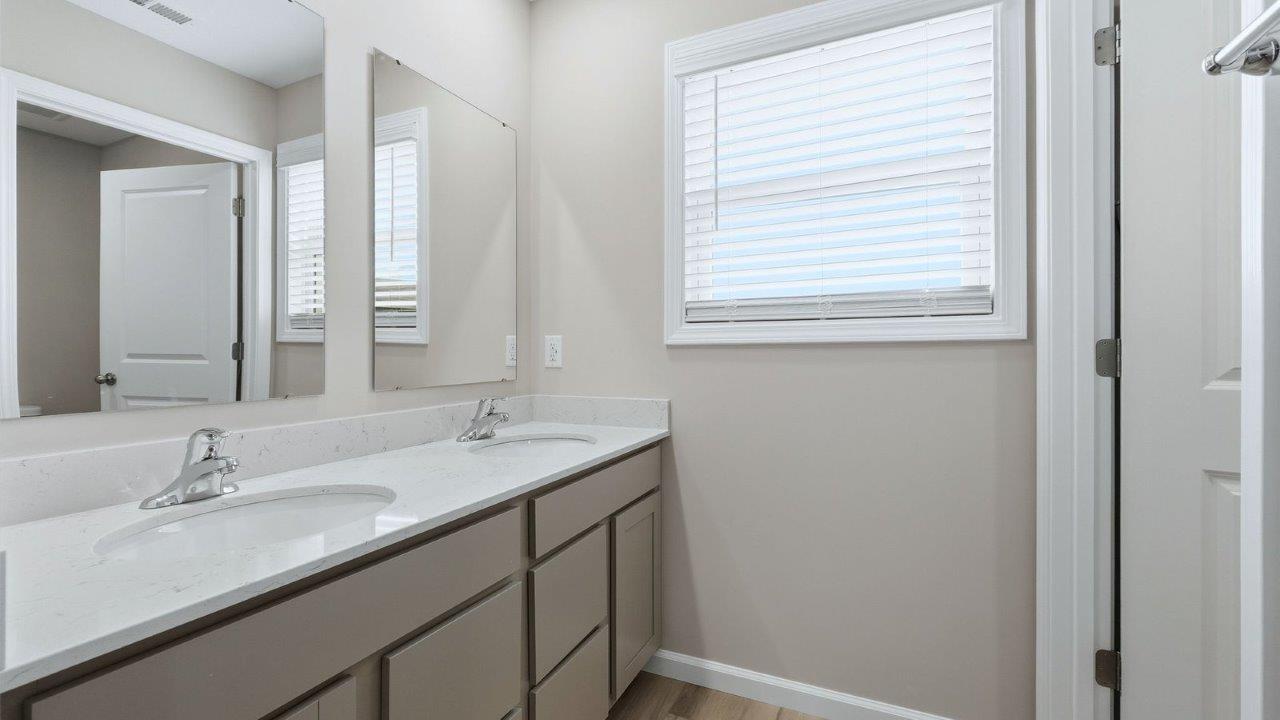 full bathroom with dual sinks, private water room, and tub shower