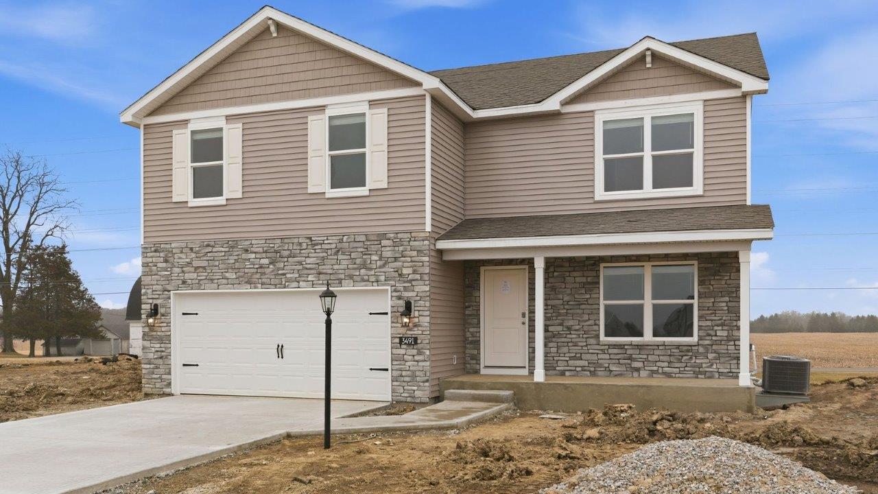fawn creek estates henley with 2 car garage, large homesite, front covered patio with moonlit trail stone, heather shake, white shutters, and heather vinyl siding