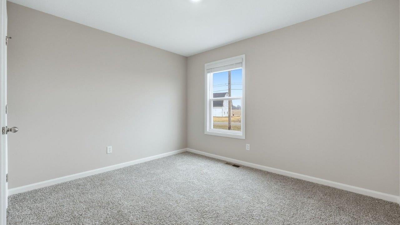 first floor guest bedroom with carpet flooring, popular grey walls, and closet