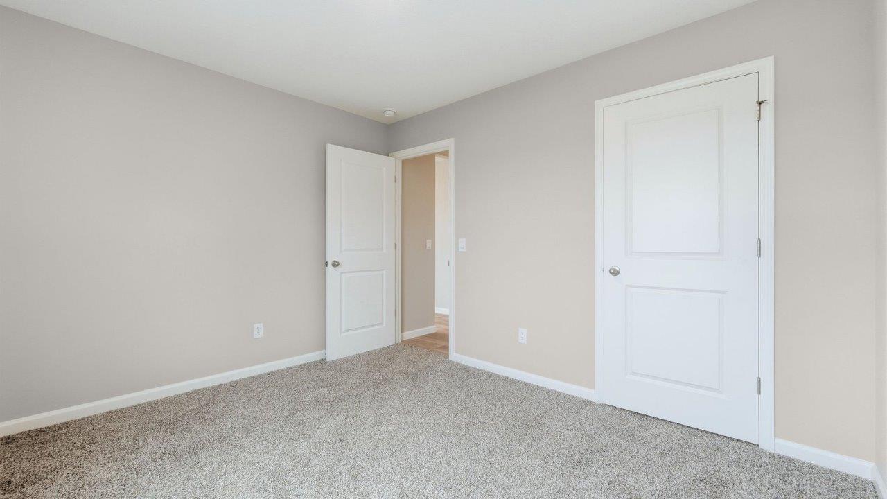 first floor guest bedroom with carpet flooring, popular grey walls, and closet