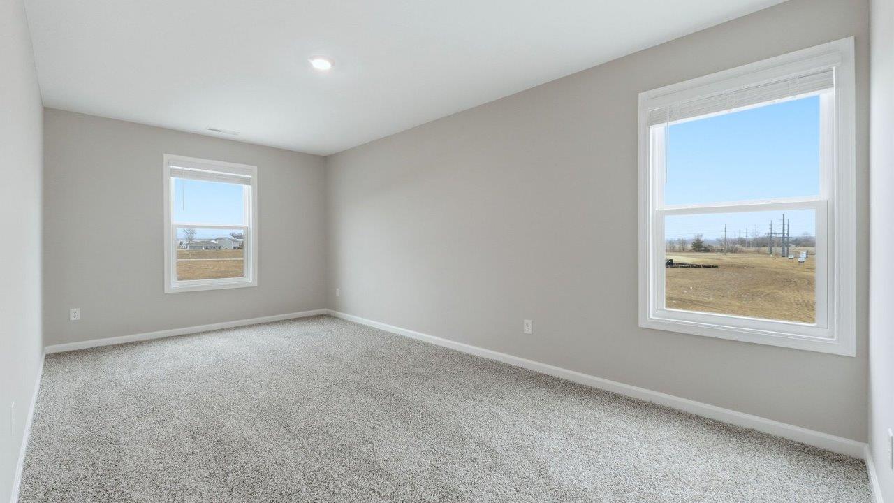 second floor living room with beige carpet, popular grey walls, and 2 windows