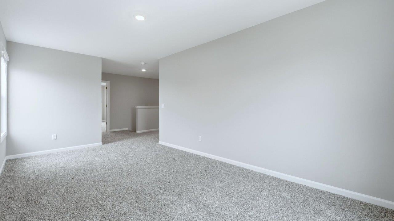 second floor living room with beige carpet, popular grey walls, and 2 windows