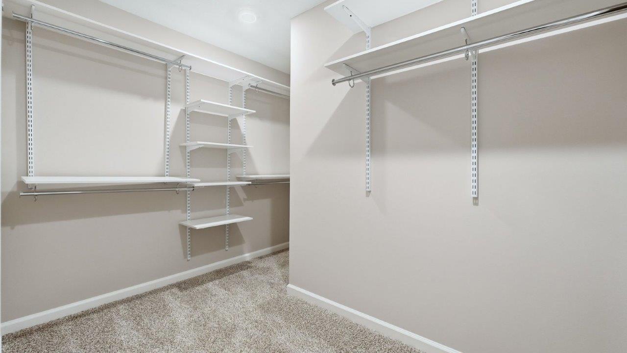 primary bedroom ensuite walk-in closet with built-in shelving