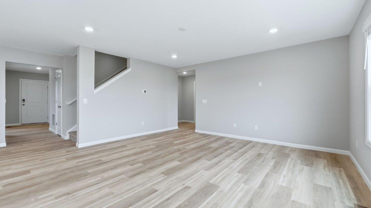 open layout living room with mohawk avery lvp, popular grey walls, and large windows