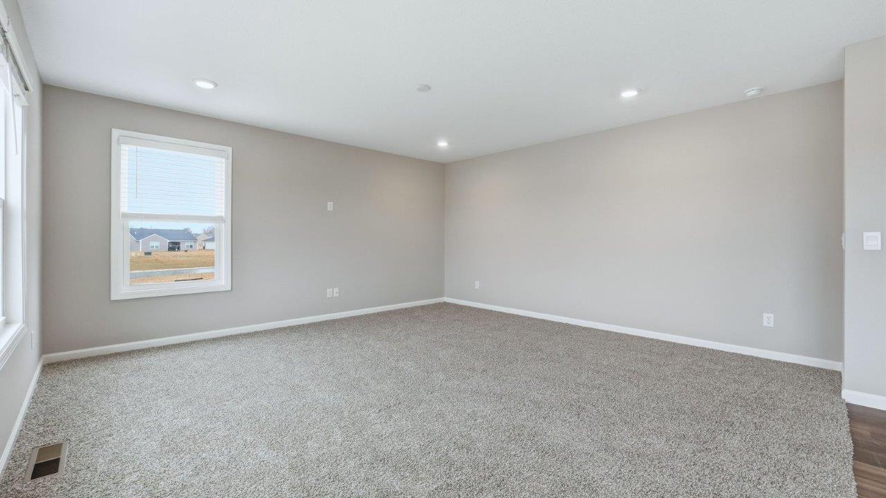 living room with carpet flooring, 3 windows, and open layout