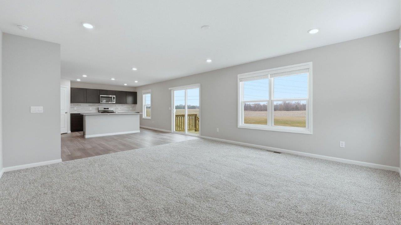 living room with carpet flooring, 3 windows, and open layout