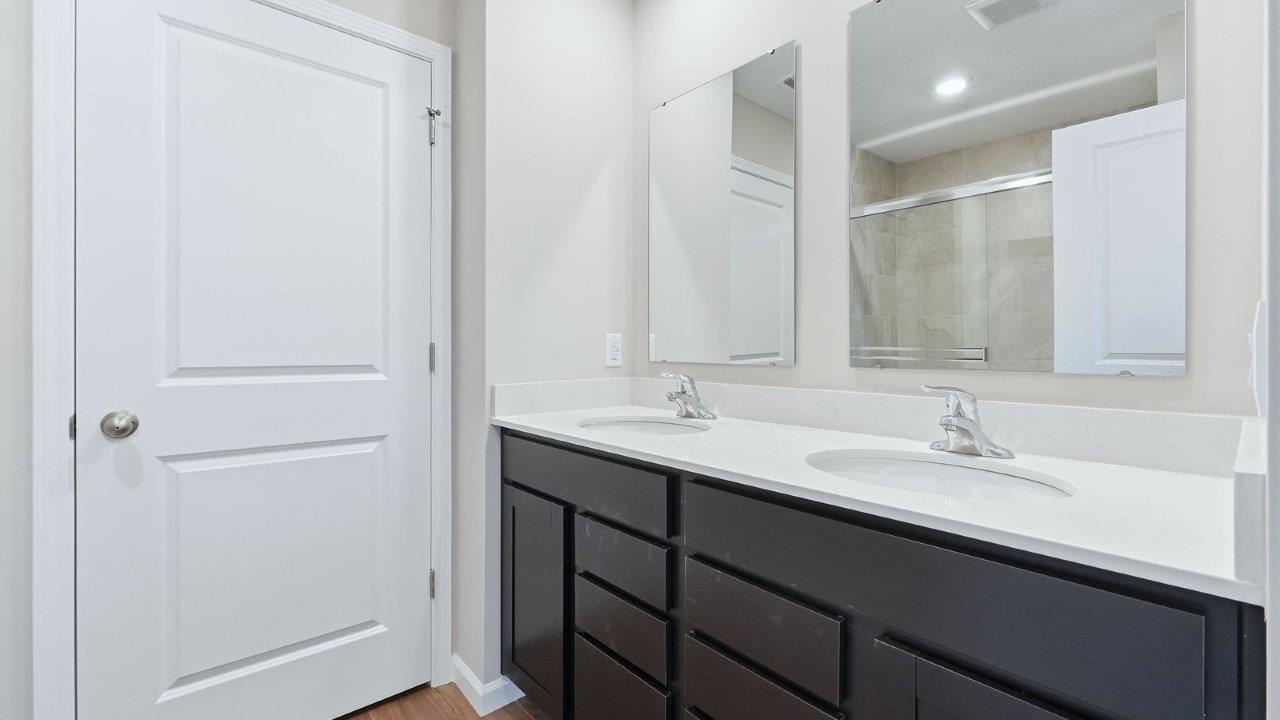 primary ensuite bathroom with dual sinks and walk-in shower