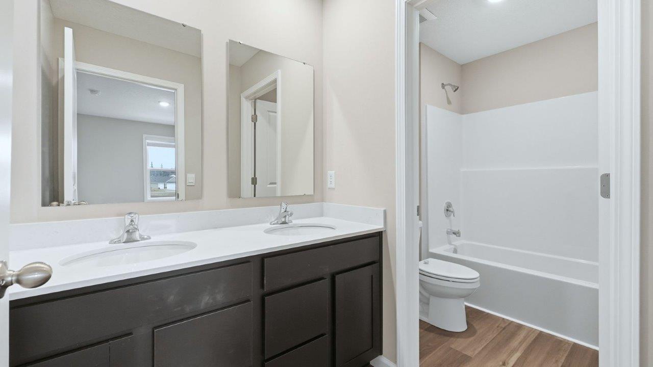 full bathroom with dual sink, lvp, tub shower, and private water room