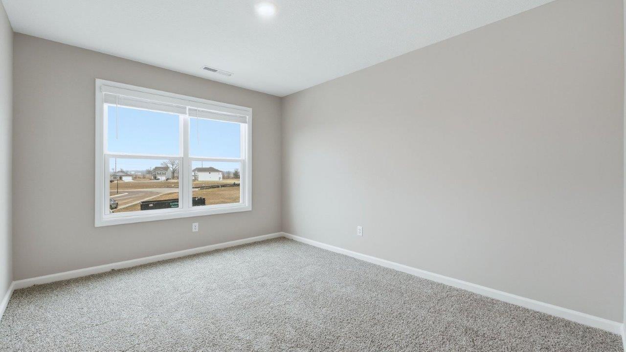 bedroom 4 with 2 windows, beige carpet, and closet