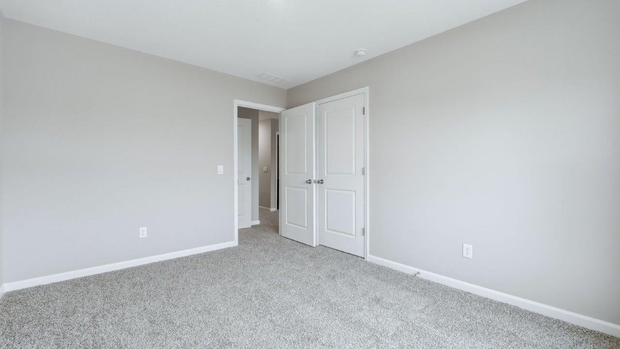 bedroom 4 with 2 windows, beige carpet, and closet